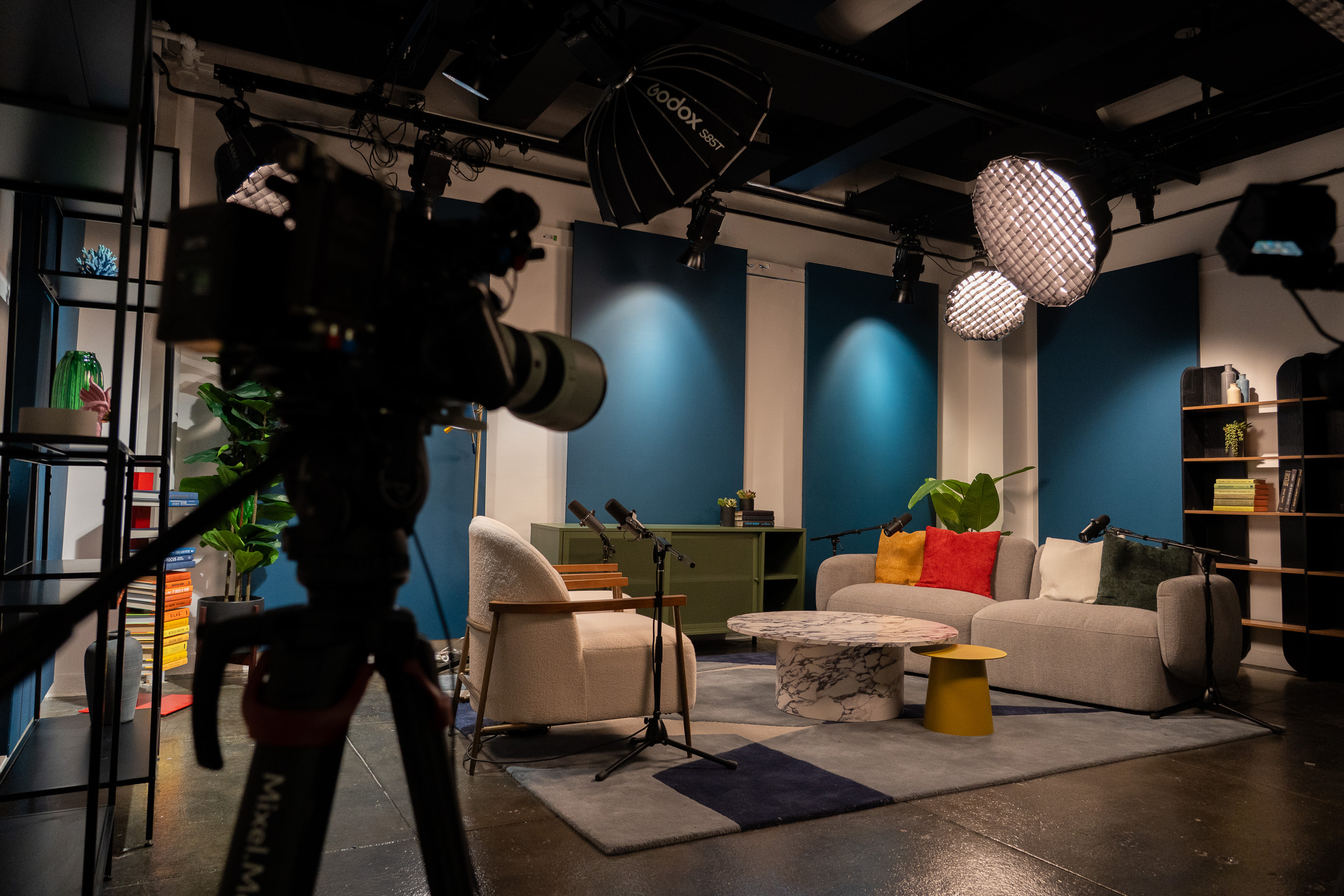 A podcast studio at Vizzcast in New York City with sofa seating and professional lighting setup.